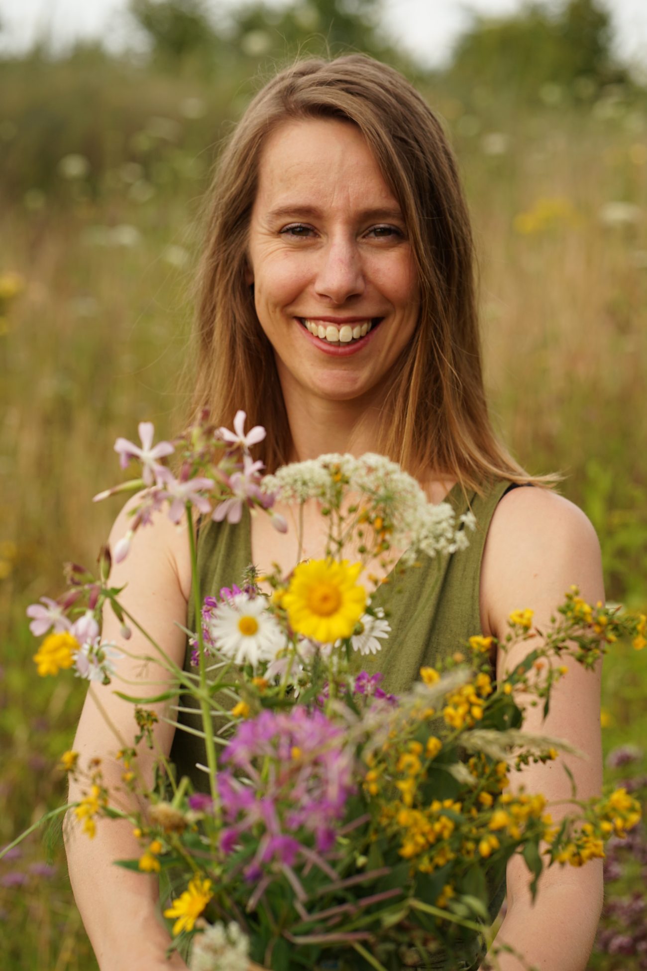 Beau Dankers met een bos wilde bloemen in een bloemenweide